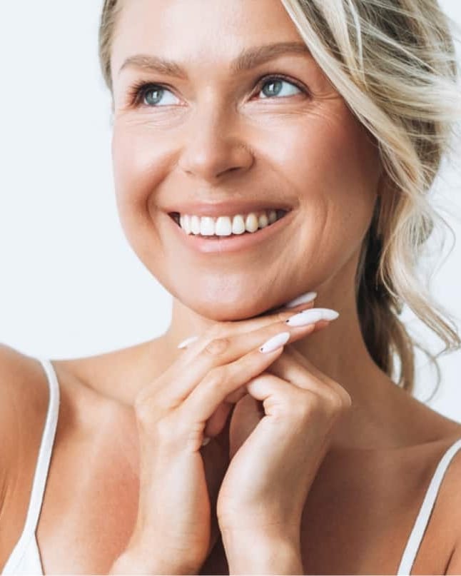 Stock photograph of a model: a smiling woman with blonde hair rests her chin on her hands