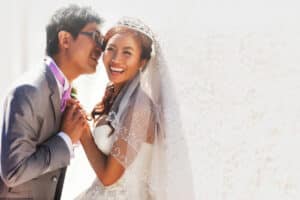 A bride being kissed by the groom on her wedding day.