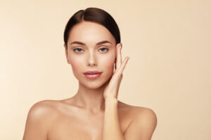 A woman posing with her hand on the side of her face, showing the results of anti-aging laser treatments in Berkeley, CA