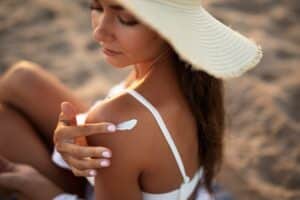 A woman applying sunscreen on her shoulder for sun protection in Northern California